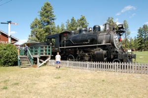 Cody in front of train at Fort Steele